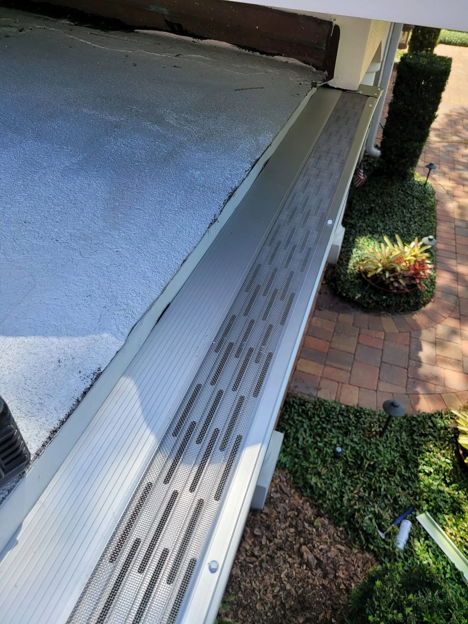 Rooftop view micro mesh gutter guard installed flat roof paver walkway, Sanford